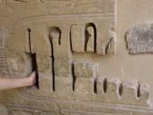 Litty steekt haar hand in een diepe hiëroglief in Medinet Haboe